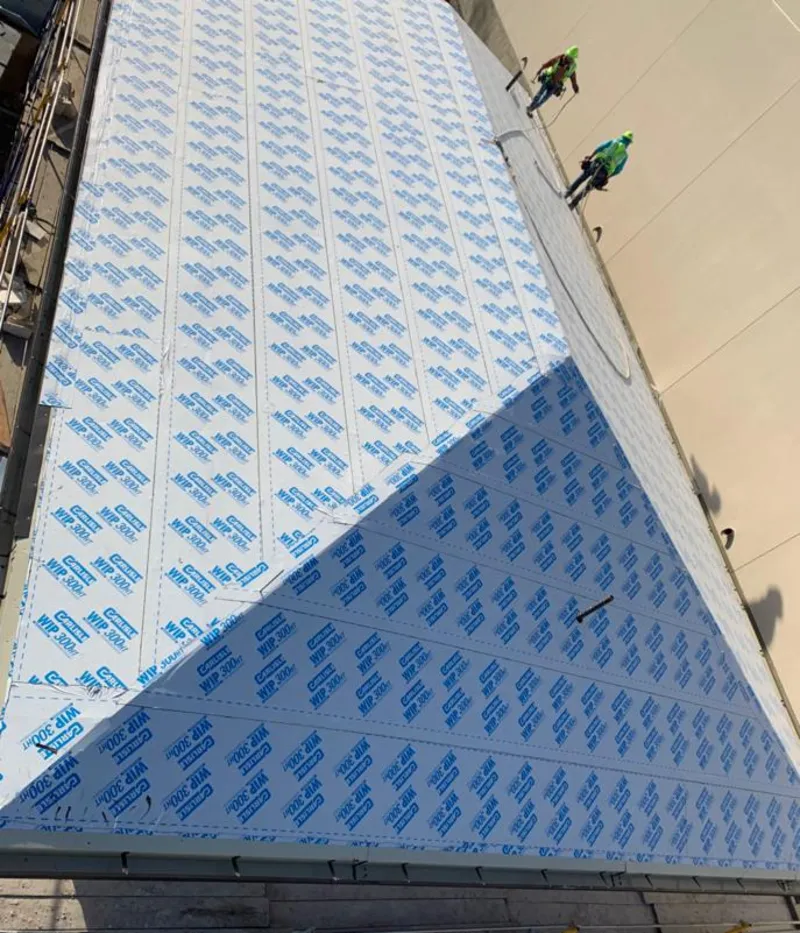 Professional roofers installing underlayment on a metal roof in Farr West